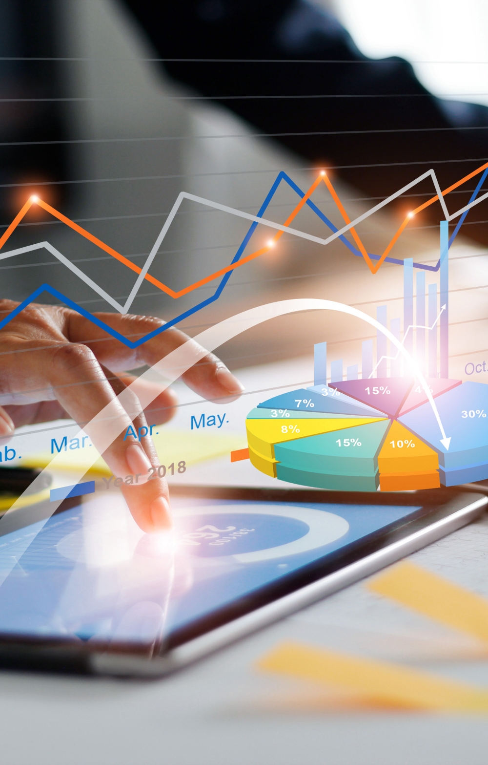 fingers of a man in a business suit tapping the screen of an iPad against a virtual statistical background with live hopping charts