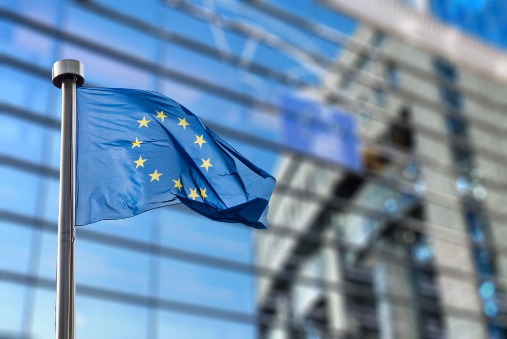 EU flag flying full mast on Berlaymont in Brussels background